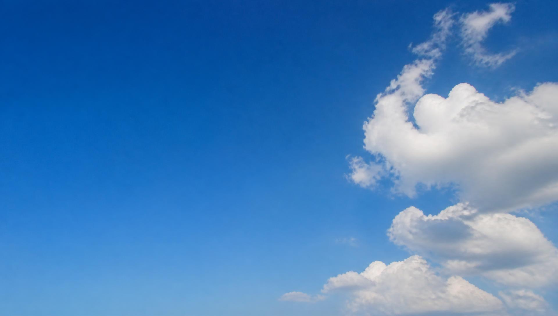 Open daytime sky with soft cumulus clouds